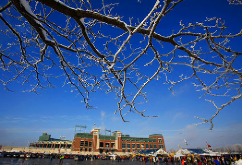 Snow hangs on the branches of a tree bordering the parking lot at Lambeau Field.
