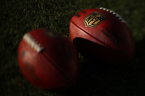 Detail shot of the NFL logo on footballs before a Packers game.