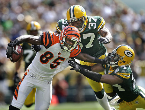 Cincinnati Bengals wide receiver Chad Ochocinco tries to break away from Green Bay Packers safety Aaron Rouse and Jarrett Bush.