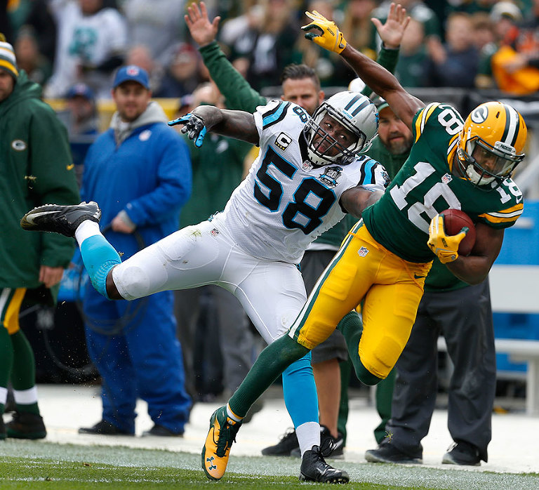 Carolina Panthers outside linebacker Thomas Davis pushes Green Bay Packers wide receiver Randall Cobb out of bounds.