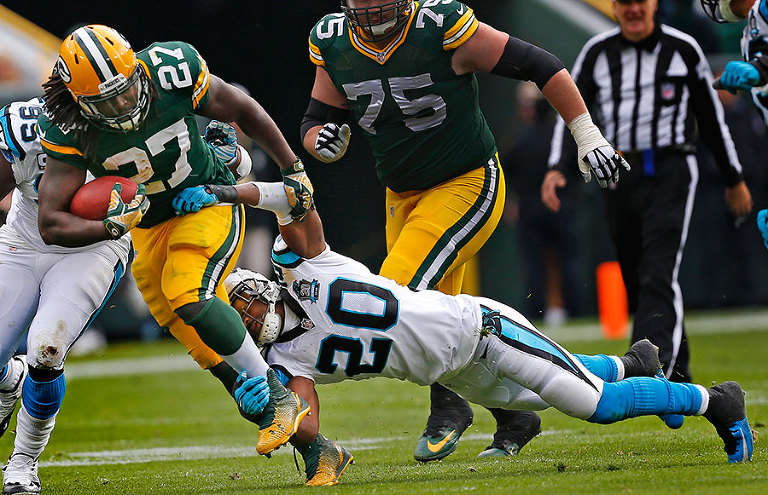 Carolina Panthers cornerback Antoine Cason tries to stop Green Bay Packers running back Eddie Lacy.
