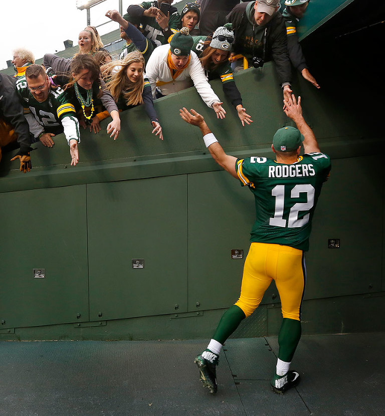 Green Bay Packers quarterback Aaron Rodgers celebrates with fans as he leaves the field after the Packers defeated the Carolina Panthers 38-17.