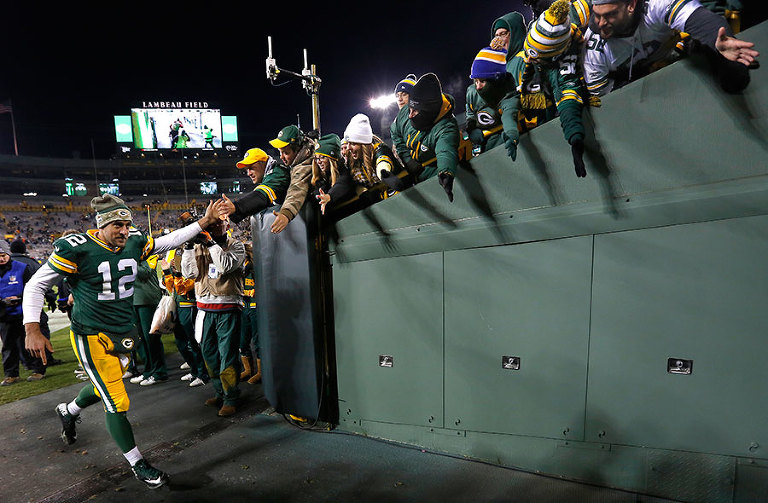 Green Bay Packers quarterback Aaron Rodgers high fives fans after his record setting win.