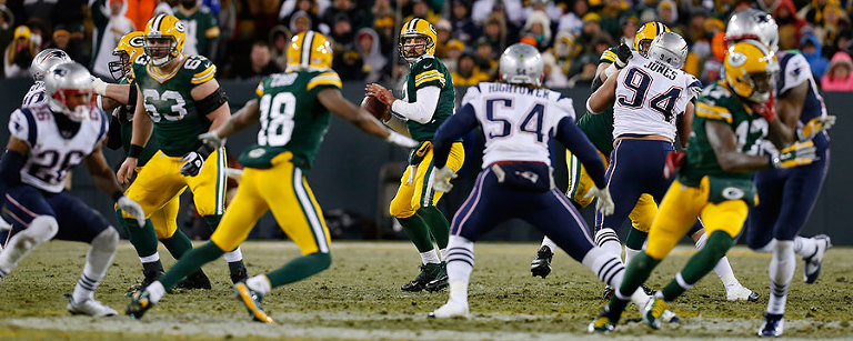 Green Bay Packers quarterback Aaron Rodgers looks for receiver.