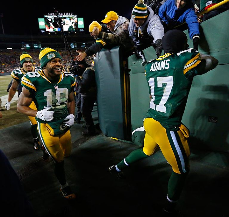 Green Bay Packers wide receivers Davante Adams, Randall Cobb and Jordy Nelson celebrate with the fans as they run off Lambeau Field after defeating the New England Patriots.