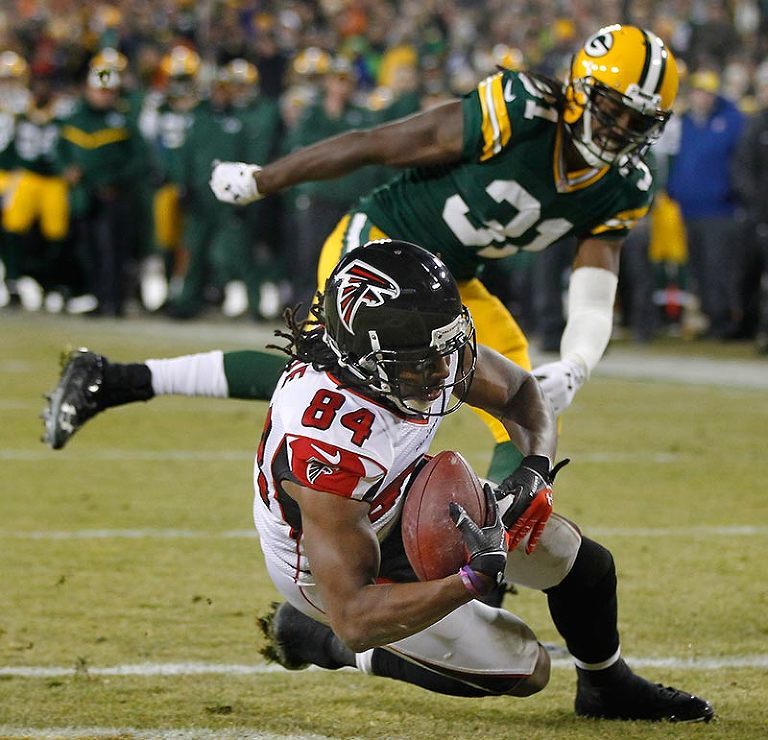 Atlanta Falcons wide receiver Roddy White catches a pass for a touchdown as Green Bay Packers cornerback Davon House defends.