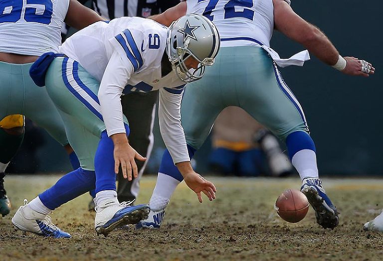 Dallas Cowboys quarterback Tony Romo chases after a fumble caused by bad snap.