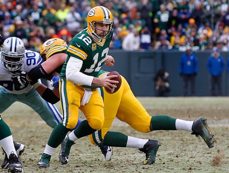 A one legged Green Bay Packers quarterback Aaron Rodgers scrambles out of the pocket before throwing a touchdown pass to tight end Andrew Quarless.
