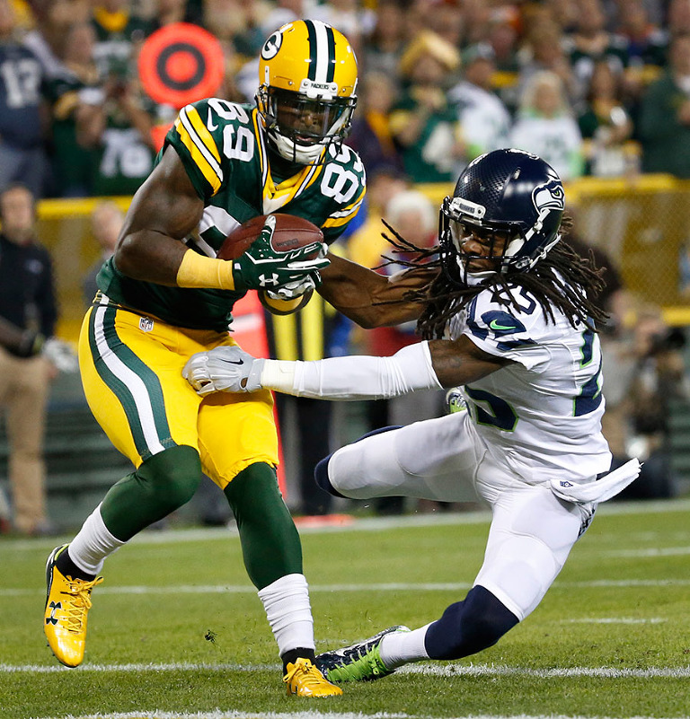 Green Bay Packers wide receiver James Jones scores a touchdown as Seattle Seahawks cornerback Richard Sherman tries to defend.