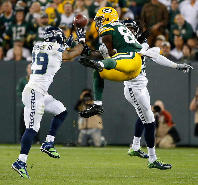 Green Bay Packers wide receiver Ty Montgomery tries to pull in a pass between the defense of Seattle Seahawks free safety Earl Thomas and cornerback Richard Sherman. Seattle got called for pass interference on the play.