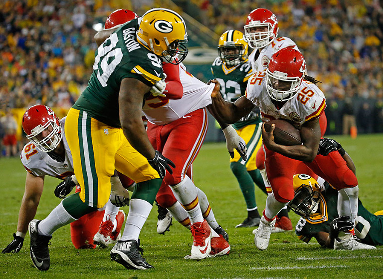 Kansas City Chiefs running back Jamaal Charles hangs on to his blockers as he scores a touchdown.