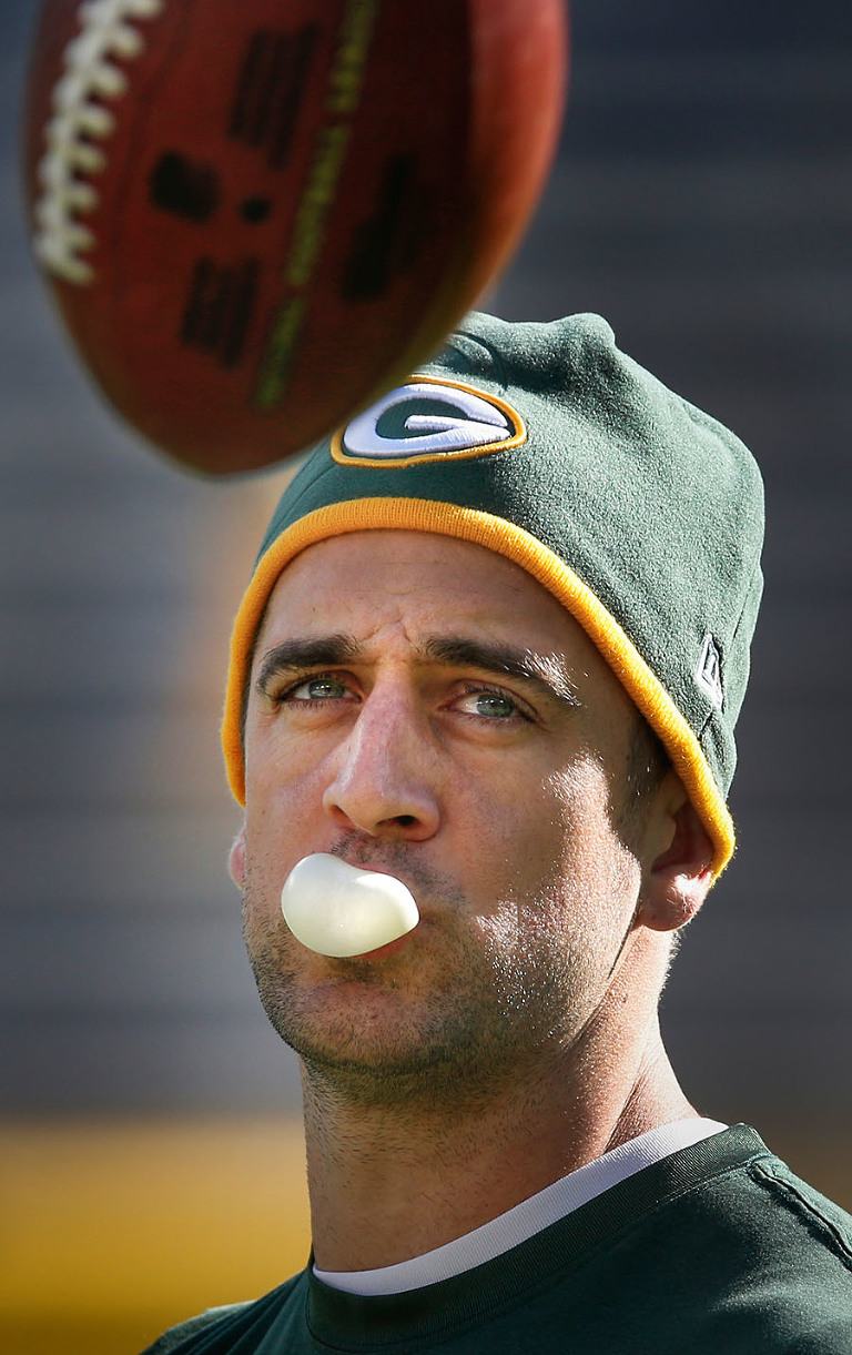 Green Bay Packers quarterback Aaron Rodgers enjoys a piece of gum while warming up before the game.