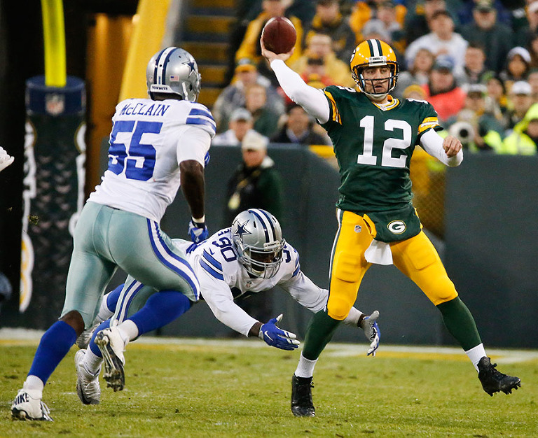 Green Bay Packers quarterback Aaron Rodgers eludes the pressure of Dallas Cowboys middle linebacker Rolando McClain and defensive end Demarcus Lawrence.