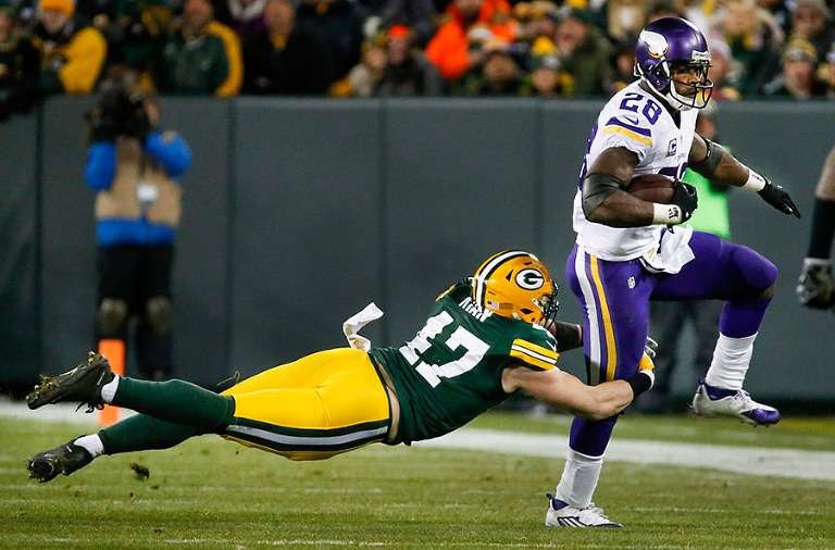 Green Bay Packers outside linebacker Jake Ryan tries to stop Minnesota Vikings running back Adrian Peterson.