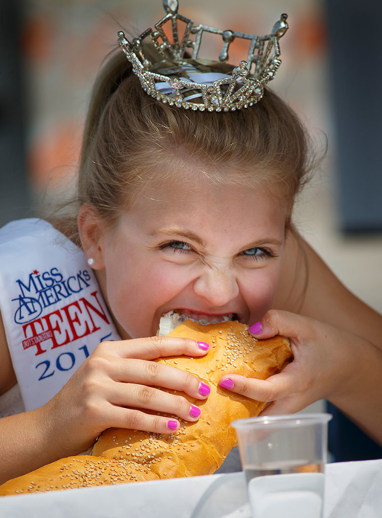 Miss Harbor Cities Outstanding Teen 2015, Sophia Pollman, takes a hearty bite out of her sandwich in the first annual sub eating contest of SubFest in Manitowoc, Wisconsin.