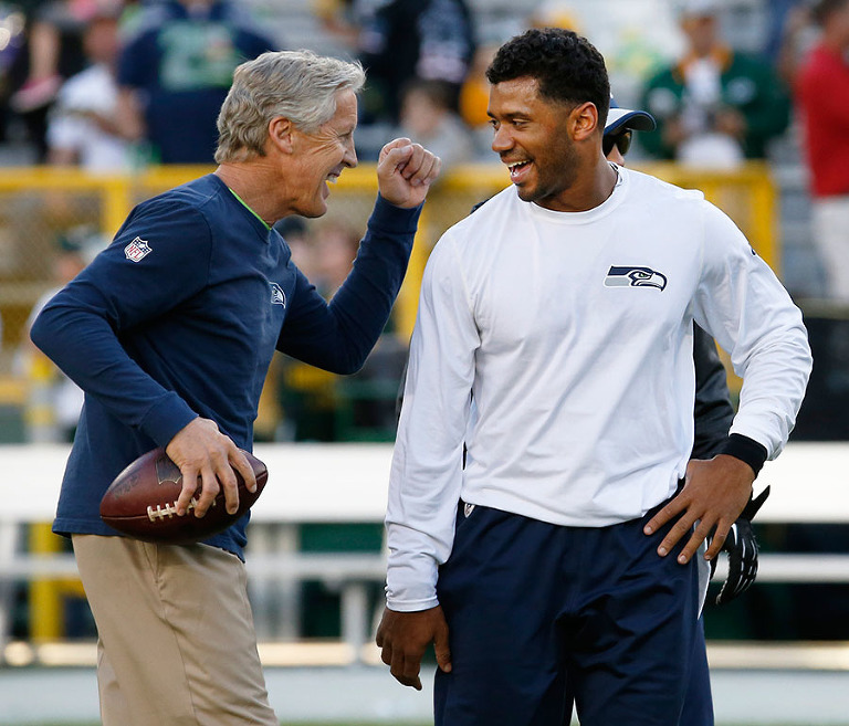 Seattle Seahawks head coach Pete Carroll jokes around with quaterback Russell Wilson before their game against the Packers.