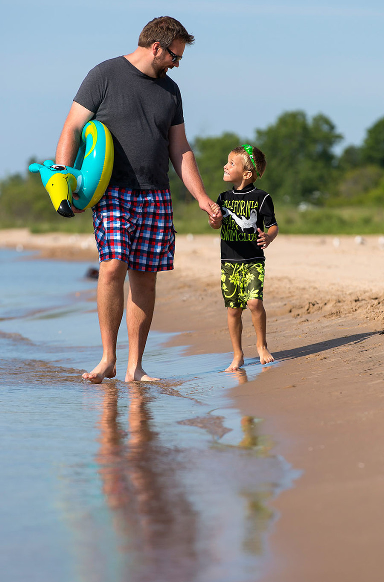 Matt Ludtke and his his son Jonah share a moment as they walk along the shoreline at Neshota Park beach in Two Rivers, Wisconsin.