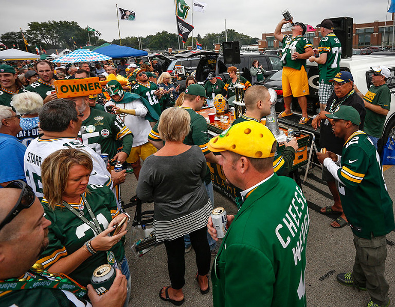 Green Bay Packers fans hydrate while tailgating.