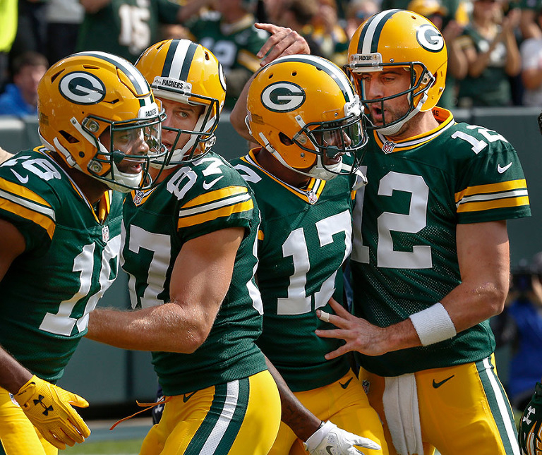 Green Bay Packers quarterback Aaron Rodgers celebrates one of his four first half touchdowns with his receiving corp.