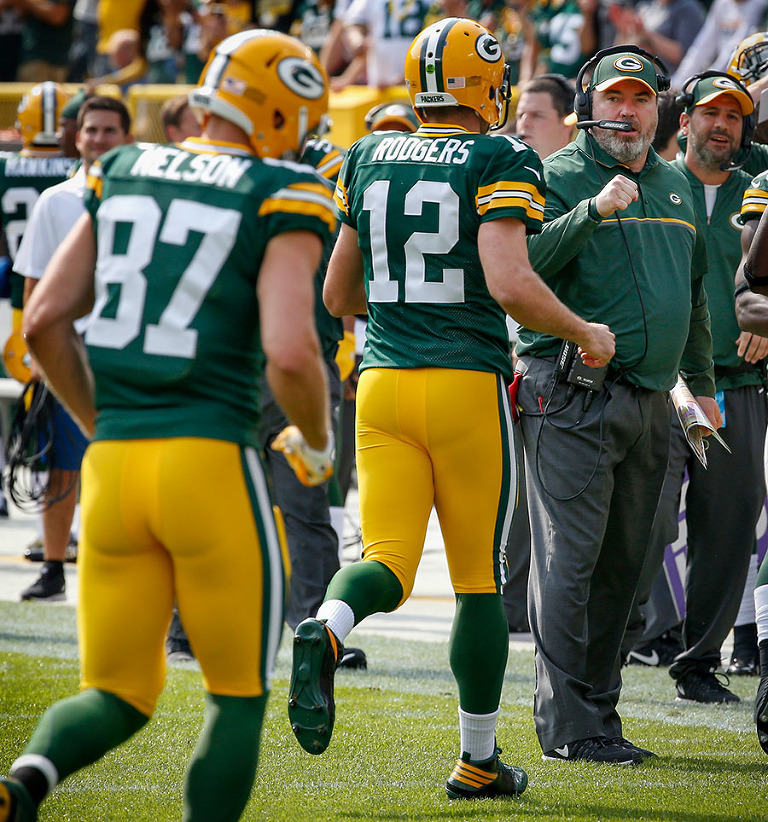 Green Bay Packers head coach Mike McCarthy celebrates a touchdown with Aaron Rodgers and Jordy Nelson.
