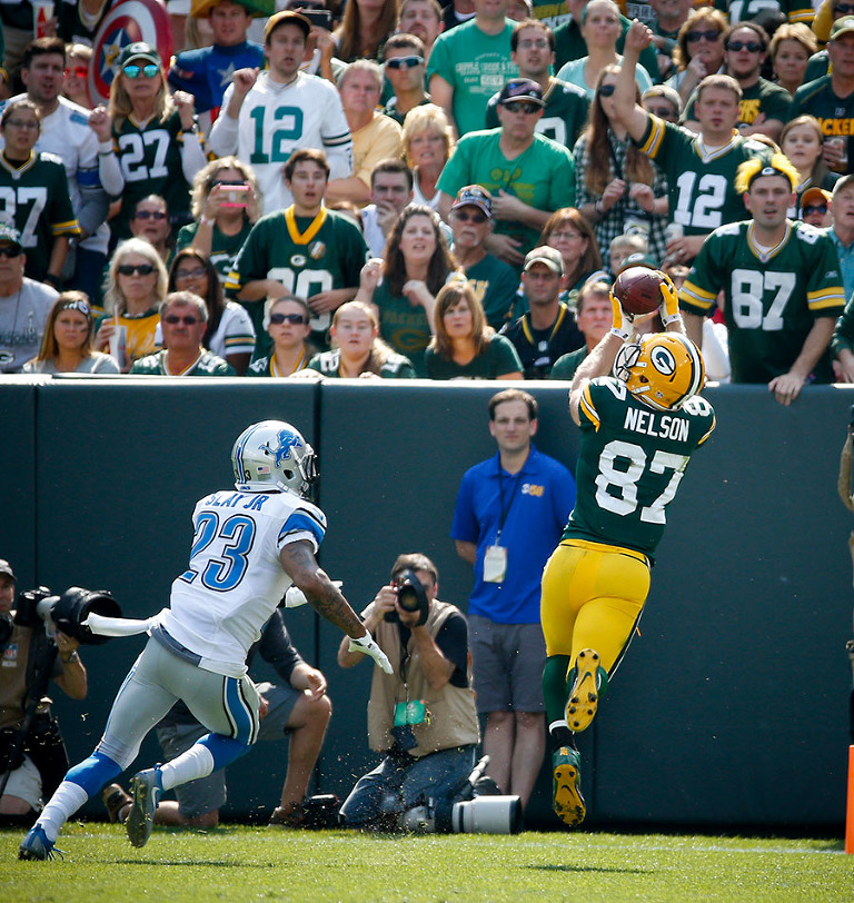 Green Bay Packers wide receiver Jordy Nelson pulls in a touchdown pass as Detroit Lions cornerback Darius Slay defends.