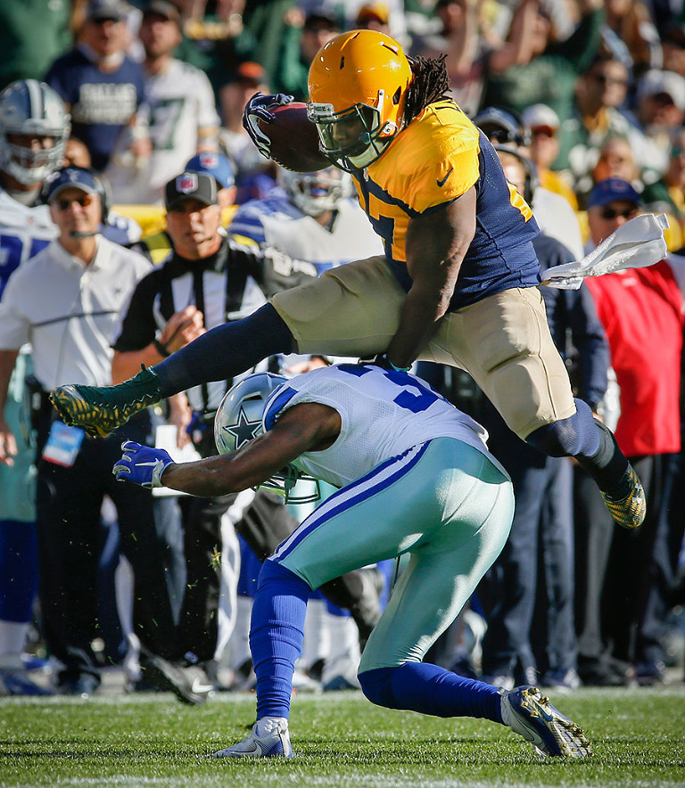 Green Bay Packers running back Eddie Lacy leaps over a Cowboys defender.