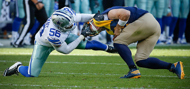 Dallas Cowboys linebacker Justin Durant takes Green Bay Packers quarterback Aaron Rodgers down by the facemask.