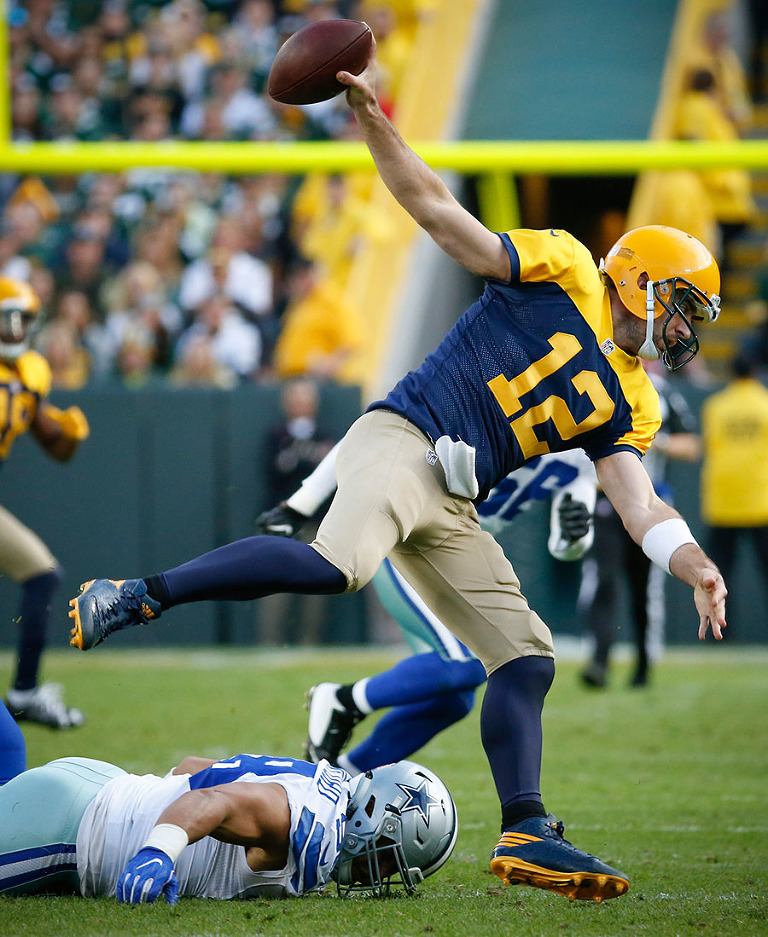 Green Bay Packers quarterback Aaron Rodgers tries to keep his balances as he escapes the Cowboys defense.