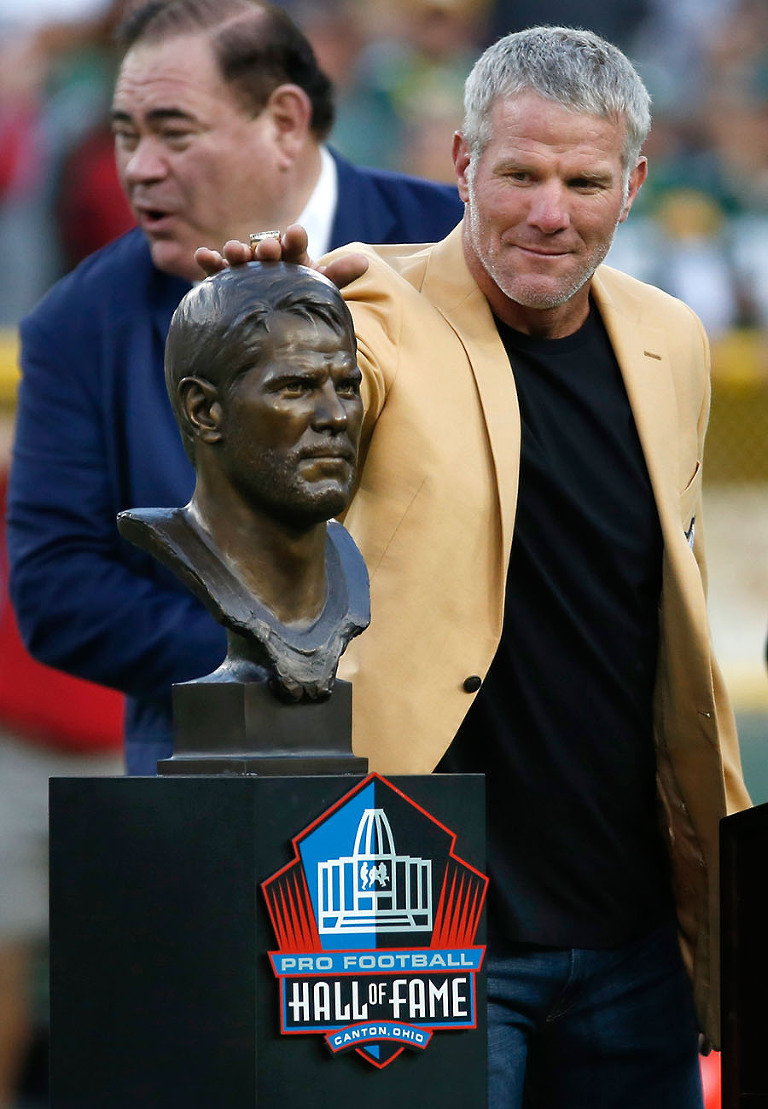 Former Packers quarterback Brett Favre pats himself on the head.