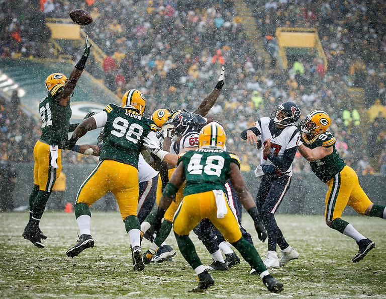 The Green Bay Packers defense pressures Houston Texans quarterback Brock Osweiler.