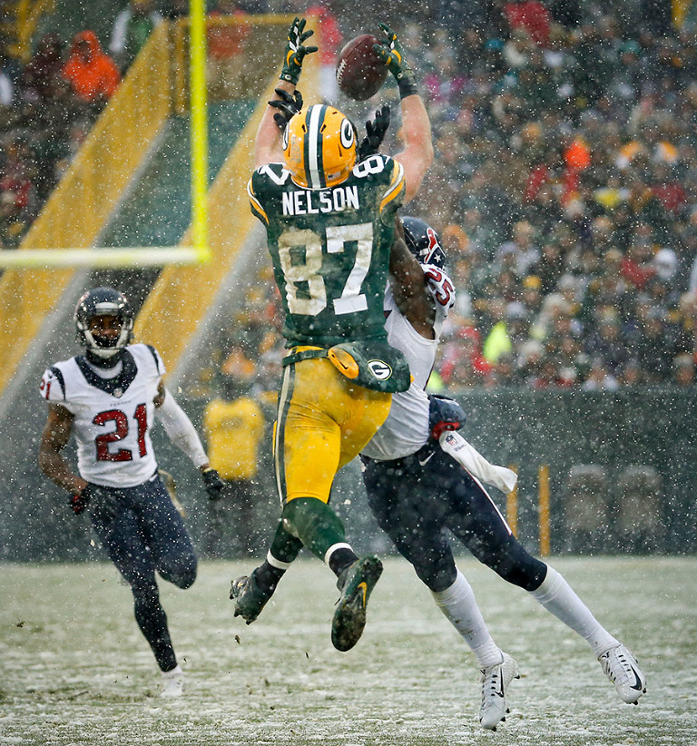 Green Bay Packers wide receiver Jordy Nelson pulls in a pass for a long gain as Houston Texans cornerback Kareem Jackson defends.