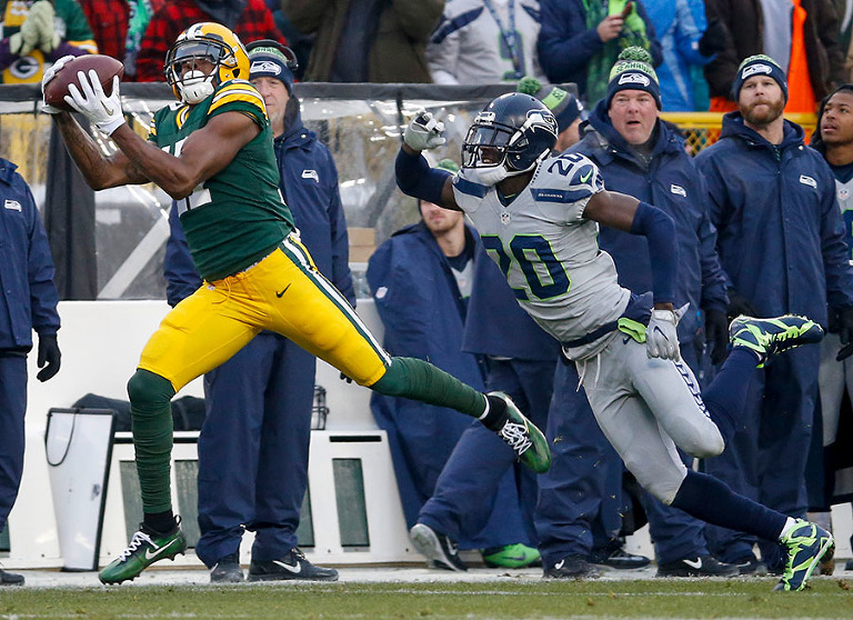 Green Bay Packers wide receiver Davante Adams pulls in a pass for a 66 yard touchdown as Seattle Seahawks cornerback Jeremy Lane defends.