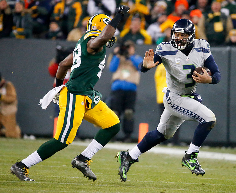 Seattle Seahawks quarterback Russell Wilson tries to elude Green Bay Packers inside linebacker Joe Thomas.